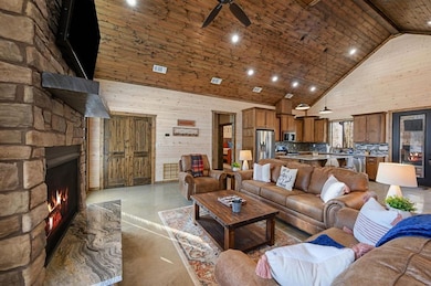 Living room with a fireplace, ceiling fan, wooden 