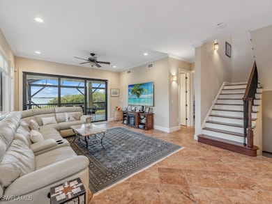 Living room featuring ceiling fan and crown moldin