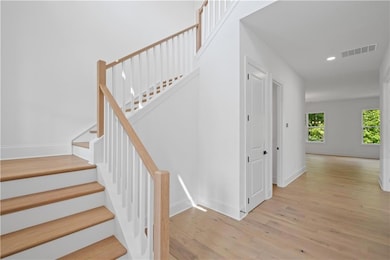 Stairway featuring wood finished floors, baseboards, and recessed lighting