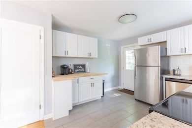 Kitchen featuring white cabinetry, appliances with stainless steel finishes, and tasteful backsplash