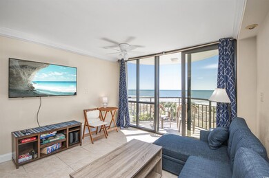 Living room featuring a wall of windows, view of water and beach, light tile patterned flooring, ceiling fan, and crown molding