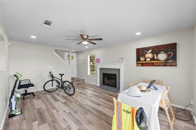 Living room with baseboards, wood finished floors, visible vents, and ceiling fan