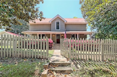 View of front of home with a porch and a fenced front yard