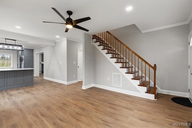 Unfurnished living room featuring stairway, light