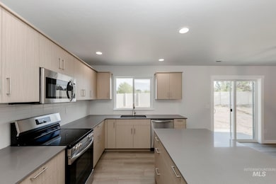 Kitchen featuring appliances with stainless steel finishes, light wood-style floors, backsplash, modern cabinets, and recessed lighting