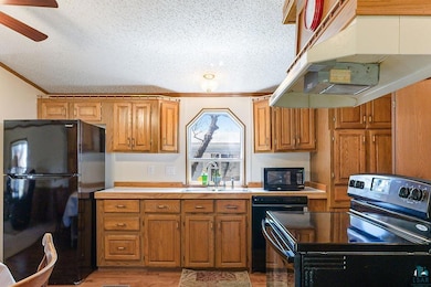 Kitchen with black appliances, a sink, crown moldi
