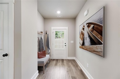 Mudroom with wood finished floors and baseboards