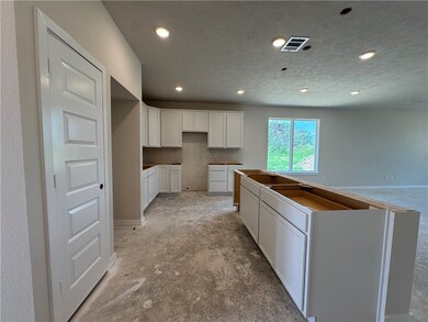 Kitchen with recessed lighting, white cabinetry, a