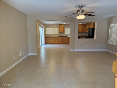 Unfurnished living room featuring a ceiling fan an
