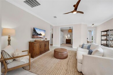 Living room with a ceiling fan, visible vents, and