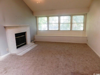 Unfurnished living room featuring plenty of natural light, carpet flooring, a fireplace, and lofted ceiling