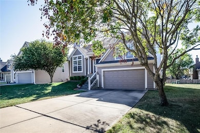 View of front of house with a garage, concrete driveway, and a front lawn