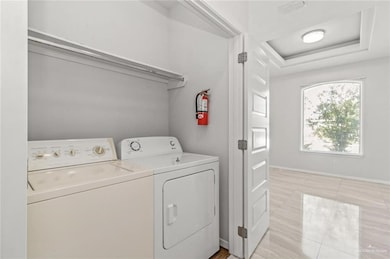 Clothes washing area with baseboards, visible vents, laundry area, and washing machine and clothes dryer