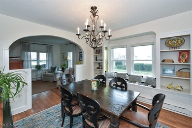 Dining space featuring an inviting chandelier, a baseboard radiator, built in features, and dark hardwood / wood-style floors