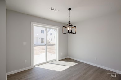 Unfurnished dining area featuring light wood-style floors and a chandelier