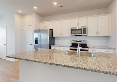 Kitchen with light stone countertops, white cabine