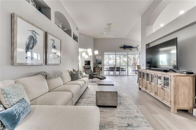 Living room featuring lofted ceiling, ceiling fan, and light hardwood / wood-style floors
