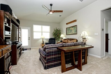 Living area featuring a ceiling fan, light colore