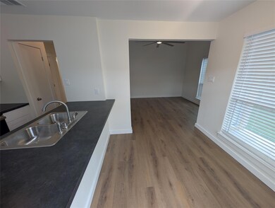 Kitchen with a sink, wood finished floors, a ceil