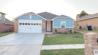 Ranch-style house with board and batten siding, an attached garage, driveway, a front lawn, and brick siding