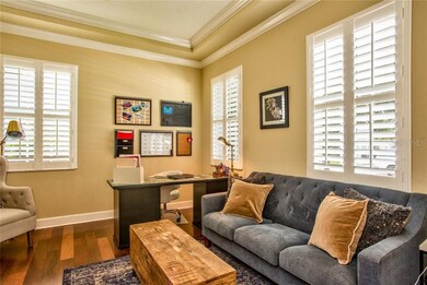 PRIVATE OFFICE WITH CROWN MOLDING, WOOD FLOORING AND PLANTATION SHUTTERS.