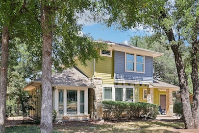 View of front of house featuring stone siding and a shingled roof