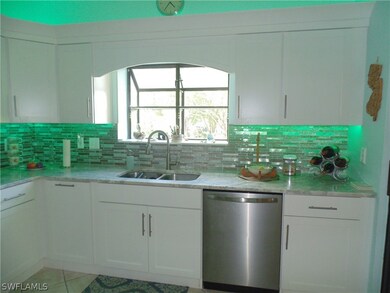 Kitchen with white cabinetry, dishwasher, backspla