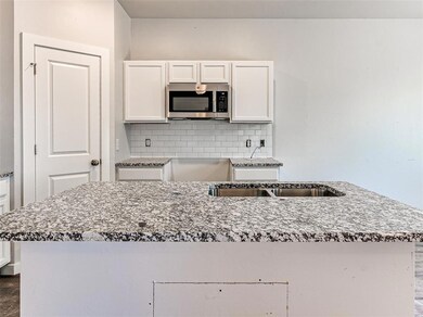 Granite countertops and an island make entertainin