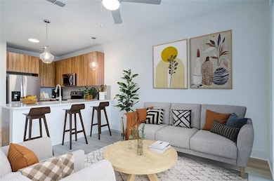 Living room with ceiling fan and light hardwood / 
