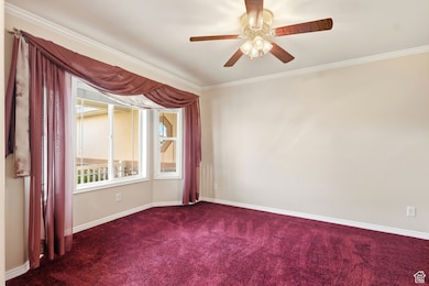 Unfurnished room with crown molding, carpet floors, and ceiling fan