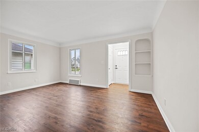 Living room featuring dark wood-type flooring, built in features, and a wealth of natural light