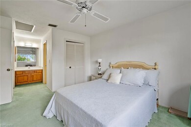 Carpeted bedroom featuring connected bathroom, cei