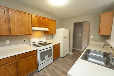 Kitchen with light countertops, a sink, light wood
