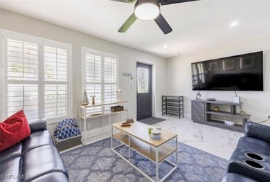 Living room featuring ceiling fan, marble finish f