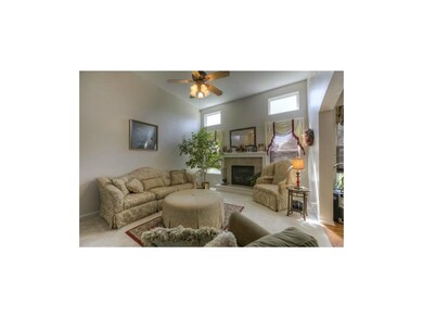 Open great room with fireplace flanked by windows