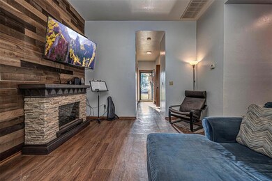 Living room with wood-style flooring and wood plank wall