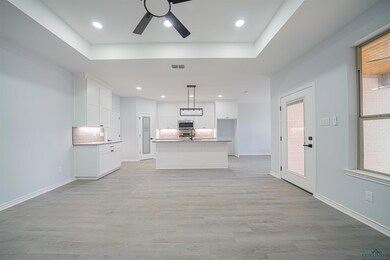 Kitchen with an island with sink, white cabinets, 