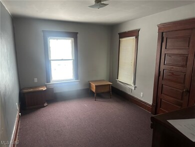 Bedroom featuring dark colored carpet and baseboards
