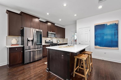 Kitchen featuring dark wood-style floors, light c
