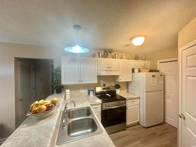 Kitchen with pendant lighting, sink, white cabinet