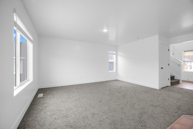 Unfurnished room featuring light carpet, stairway, and recessed lighting