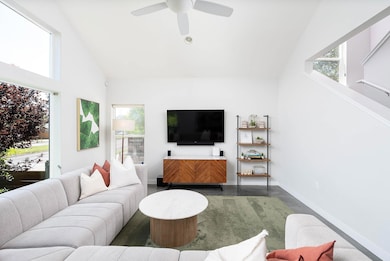 Living area featuring a ceiling fan and high vaul