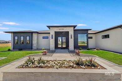 Property entrance with french doors, stone siding, a yard, and stucco siding