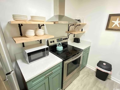 Kitchen with electric stove, light hardwood / wood