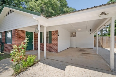 View of front facade with brick siding and a carport