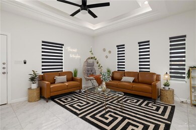 Living room with light tile floors, a raised ceiling, and ceiling fan