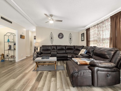 Living room featuring ceiling fan, ornamental mold