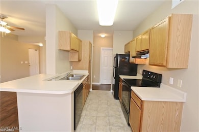 Kitchen with light brown cabinets, a peninsula, bl