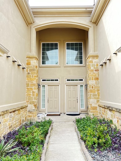 Property entrance with stucco siding and stone si