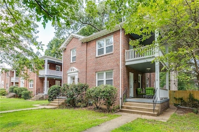 View of front of house featuring a balcony, brick